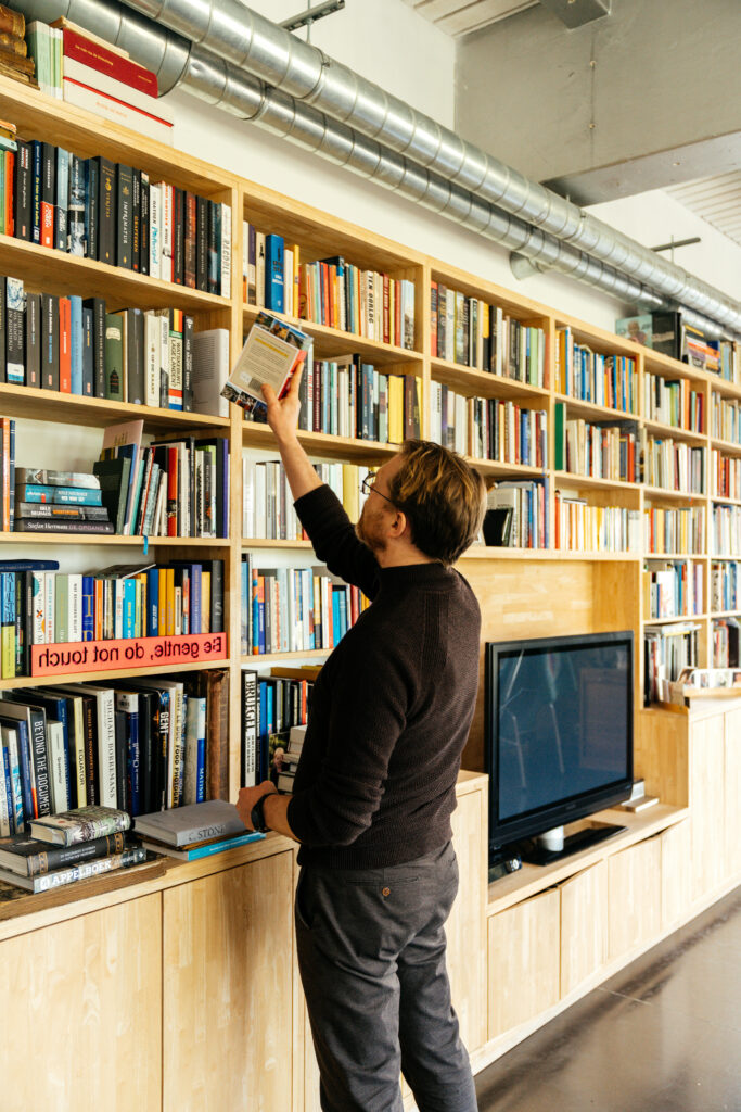 Steven voor het boekenrek in de loods